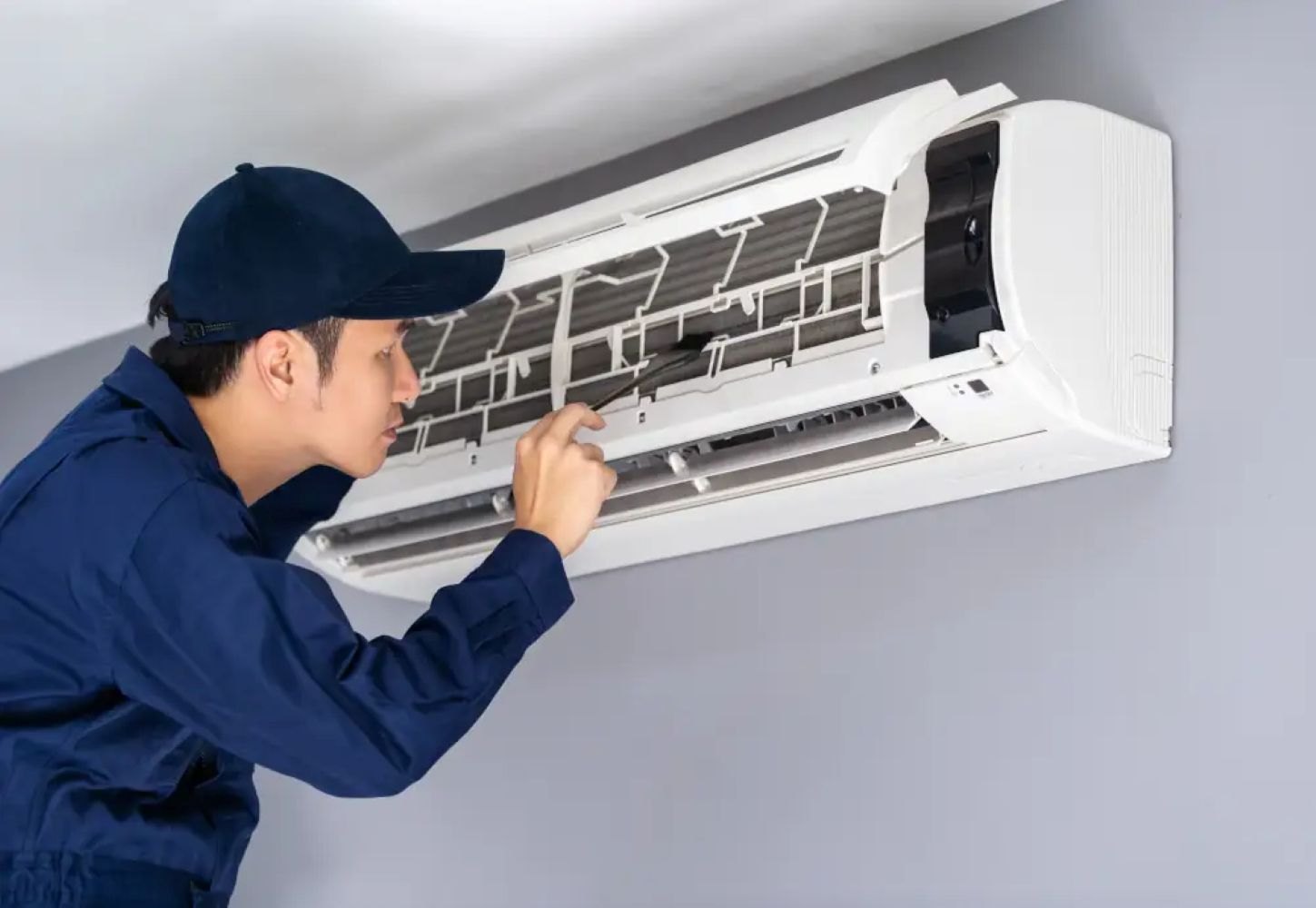 Technician servicing air conditioner unit